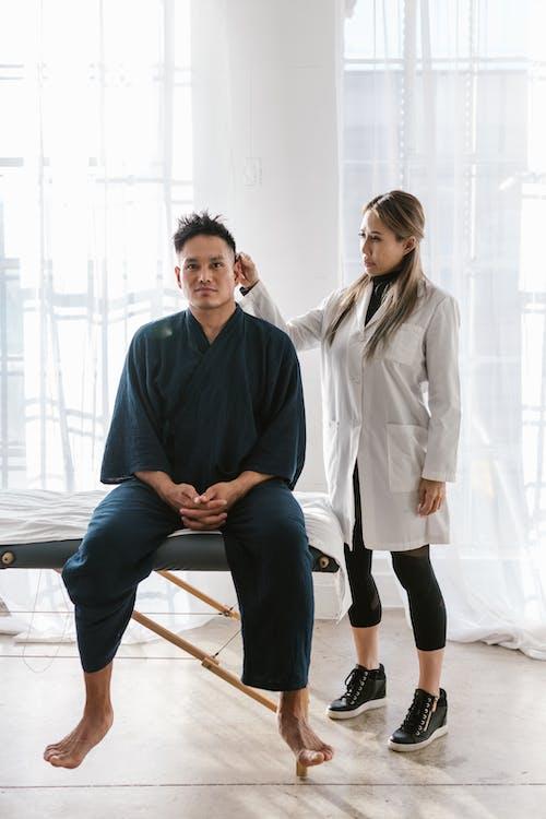 A chiropractic practitioner improving the spinal alignment of a man in a black dress